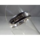 A 14 carat white gold unisex ring set with eight princess cut diamonds,