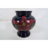 Moorcroft Pottery - a small Moorcroft Pottery vase / urn decorated with columbine on a blue ground,