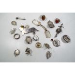 A collection of silver trinkets lapel badges and similar.