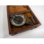 An early 20th century surveyors compass in cloth lined wooden travel case with metal tripod