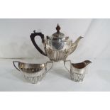 A George III hallmarked silver teapot, sugar bowl and creamer, Birmingham assay,