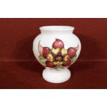 Moorcroft Pottery - a small Moorcroft Pottery vase / urn decorated with columbine on a cream ground,
