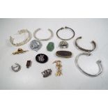 A collection of white metal brooches, pin badges, bangles and similar of which some silver,