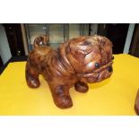 A large faux leather footstool in the shape of a dog.