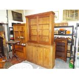 A substantial early pine bookcase with sliding glazed doors,
