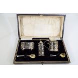 A George V silver cruet set with pierced decoration in presentation case, Birmingham assay,