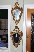 Pair shaped gilt framed wall mirrors with mask crests