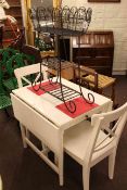 White drop leaf kitchen table and two chairs together with a cast metal plant stand