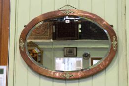 Early 20th Century copper and brass oval mirror in Arts and Crafts style,