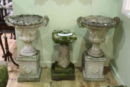 Pair weathered campana style two handled garden urns on pedestal bases,