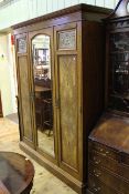 Victorian walnut triple wardrobe having central mirror door flanked by two panelled doors bearing