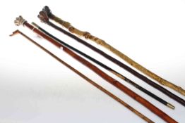 Four walking sticks each with dog head handles and small cane
