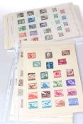 Ten pages of WWII Third Reich stamps including rare assault/defence mint sets