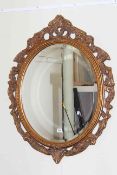 Oval gilt framed bevelled wall mirror