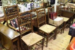 Oak drop leaf dining table on pad feet and six oak rush seated dining chairs including one carver
