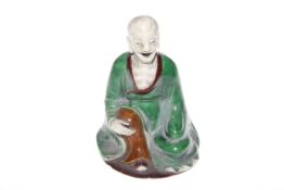 Chinese green and brown glazed figure of a seated elder,