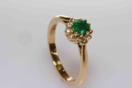 18 carat gold oval emerald and round brilliant diamond cluster ring,