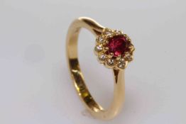18 carat gold, oval ruby and round brilliant cut diamond cluster ring,