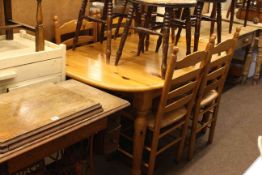 Oval pine extending dining table and four rush seated ladder back chairs