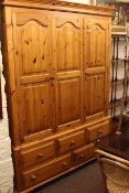 Pine wardrobe having two arched panel doors above five drawers,