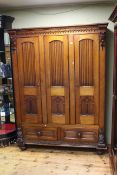 Victorian pitch pine wardrobe having three panelled doors above two drawers