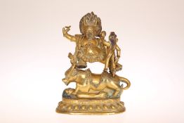A GILT-BRONZE FIGURE OF THE BUDDHA, POSSIBLY TIBETAN, modelled astride an ox,