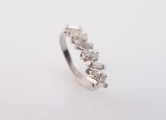 A DIAMOND RING, the three oval cut diamonds alternately set with four baguette cut diamonds,