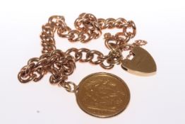 A HEAVY CURB LINK BRACELET, with heart padlock clasp and half Sovereign charm.