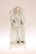 A 19TH CENTURY STAFFORDSHIRE FIGURE OF WELLINGTON, modelled seated with crossed legs,