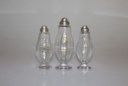 A SET OF THREE GEORGE V SILVER TOPPED CONDIMENTS, London 1915,