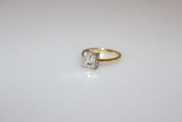 AN EMERALD CUT DIAMOND RING, with tapering shoulders, hallmarked 18 carat yellow gold.