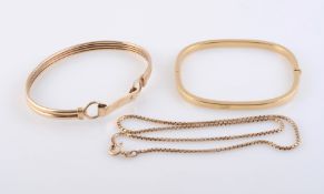 TWO GOLD BANGLES, one oval shaped with hook style fastening,