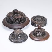 A GROUP OF FOUR CHINESE CARVED AND PIERCED VASE AND JAR COVERS.