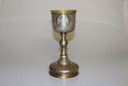 A LARGE GREEK WHITE METAL CHALICE, with engraved decoration and baluster stem.