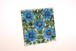 A WILLIAM DE MORGAN TILE, painted with a spray of blue flowers, unmarked.