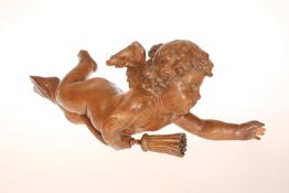 AN ITALIAN CARVED PINE FIGURE OF A PUTTO, c.