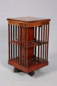 AN EDWARDIAN INLAID MAHOGANY REVOLVING BOOKCASE, the square moulded top with satinwood inlay,