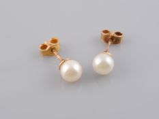 A PAIR OF CULTURED PEARL EARRINGS, on yellow gold post and scroll fittings. Scrolls stamped 9K.