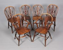 A NEAR SET OF SIX 19TH CENTURY ELM AND OAK WINDSOR WHEELBACK CHAIRS, including two carvers,