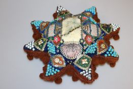 A FIRST WORLD WAR SWEETHEART CUSHION, of star shape, elaborately decorated with coloured beads,