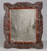 A CHINESE CARVED AND PIERCED HARDWOOD MIRROR, 19TH CENTURY, the broad surround carved with figures,