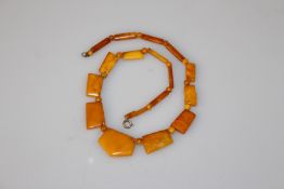 AN AMBER NECKLACE, of circular, flattened and pentagonal yellow beads.