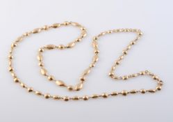 A GOLD COLOURED NECKLACE, formed of alternate circular and oval mounts with faceted detailing,