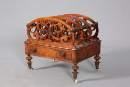 A VICTORIAN WALNUT CANTERBURY, with four fret carved dividers and drawer, moving on castors. 50.5cm.