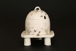 A FIRST PERIOD BELLEEK GRASS PATTERN HONEY POT AND COVER, in the form of a wicker skep on stand,