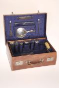 A GEORGE V SILVER TRAVELLING TOILET SET, Birmingham 1910, in an initialled leather case,