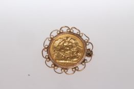 HALF SOVEREIGN, with moulded mount and brooch pin.
