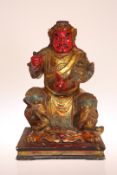 A LARGE CHINESE POLYCHROME AND GILTWOOD FIGURE OF A SEATED WARRIOR, depicted clad in armour,