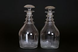 A PAIR OF GEORGIAN GLASS DECANTERS, with ring necks and bullseye stoppers. 23.