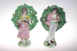 Pair Continental porcelain bocage figures in early 19th Century costume,